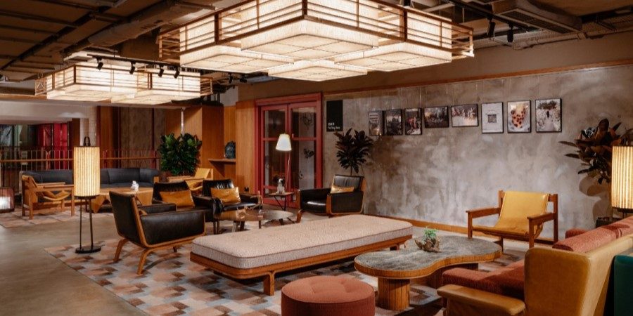 Modern hotel lobby at Eaton HK featuring a large, elegant chandelier illuminating the space.